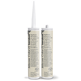 Two Kerakoll Silicone Color cream sealant tubes standing upright, one with nozzle attached and one with cap.