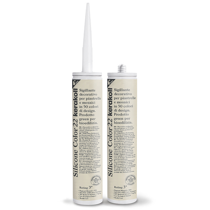 Two Kerakoll Silicone Color cream sealant tubes standing upright, one with nozzle attached and one with cap.