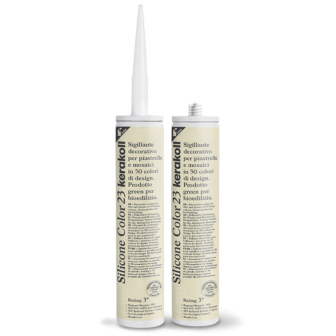 Two Kerakoll Silicone Color cream sealant tubes standing upright, one with nozzle attached and one with cap.
