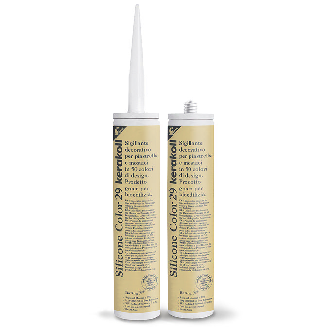 Two Kerakoll Silicone Color yellow sealant tubes standing upright, one with nozzle attached and one with cap.