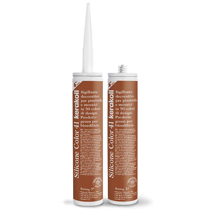 Two Kerakoll Silicone Color orange sealant tubes standing upright, one with nozzle attached and one with cap.