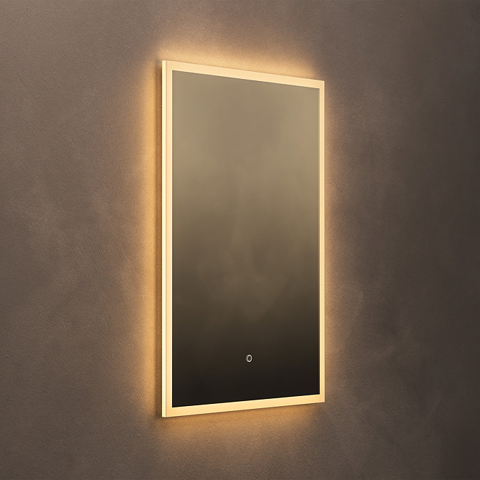 The Roxbury 600 x 800mm Illuminated Rectangular Mirror with Demister Pad pictured on a plain beige wall, showing the mirror omitting a warm glow.
