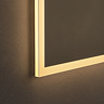 Close up of the bottom corner of the Roxbury 600 x 800mm Illuminated Rectangular Mirror, showing the light strip's warm-toned glow.