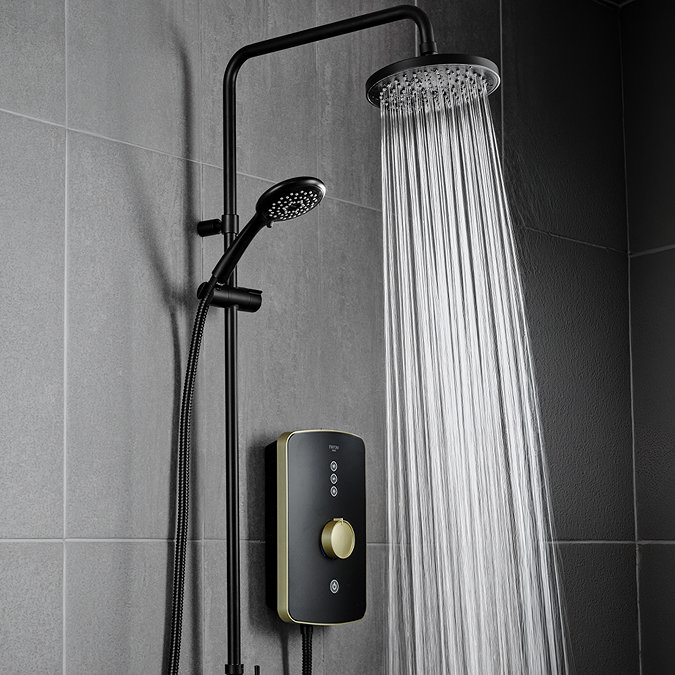 Triton Amala DuElec 9.5kW electric shower in brushed brass and black, showing the rainfall shower head in use with water flowing and the handheld shower mounted on the riser rail.
