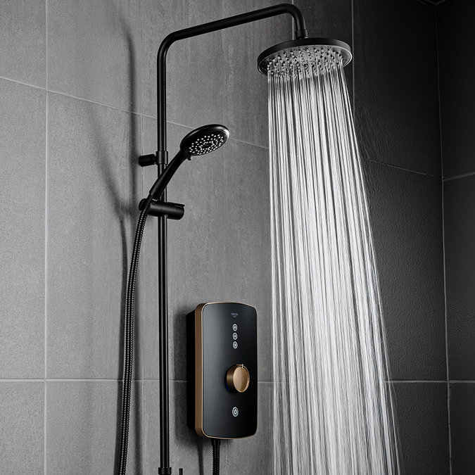 Triton Amala DuElec 9.5kW electric shower in brushed copper and black, showing the rainfall shower head in use with water flowing and the handheld shower mounted on the riser rail.